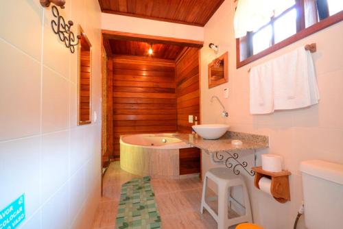 卢米亚Pousada Fonte Viva - Lumiar的带浴缸和盥洗盆的浴室