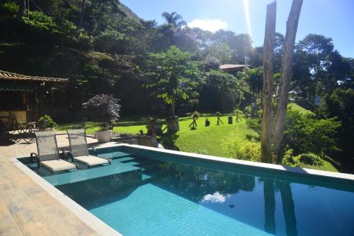 彼得罗波利斯Bela vista - Secretário的一个带两把椅子的游泳池和一个花园