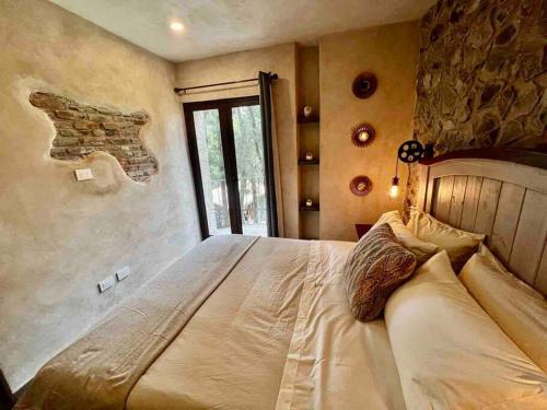 SanteaguedaIncreíble Loft Completo en Val'Quirico的一间卧室设有一张带石墙的大床