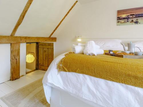 伍德布里奇Angel Lane的一间卧室配有一张带白色床单和金色毯子的大床。