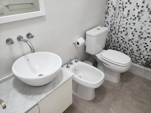 罗萨里奥Departamento Vera Mujica 3 cochera propia incluida的白色的浴室设有水槽和卫生间。