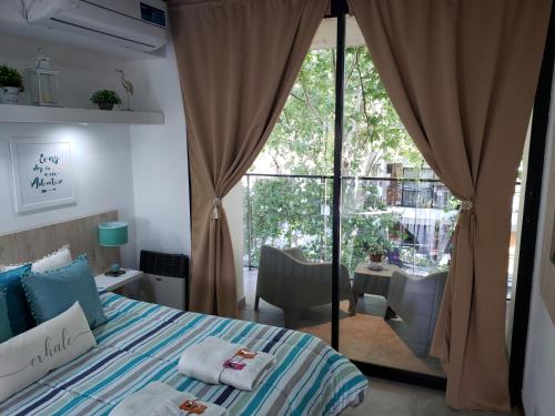 罗萨里奥Departamento Vera Mujica 3 cochera propia incluida的一间卧室设有一张床和一个大窗户