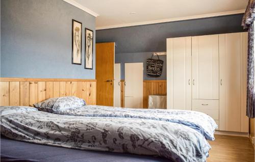 EtnesjøenCozy Home In Etne With Wifi的卧室设有两张床铺和蓝色的墙壁