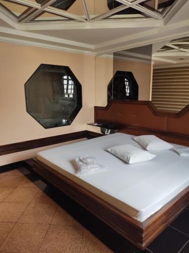 里约热内卢Champion motel的一间卧室配有一张带镜子的床和一台电视