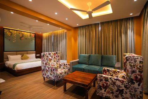 维杰亚瓦达HOTEL SUNRISE HOSPITALITY的客厅配有床、沙发和椅子