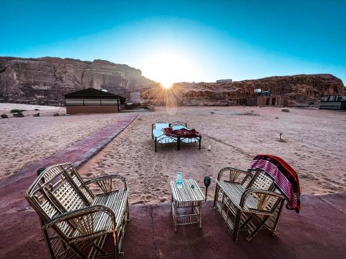 瓦迪拉姆Bedouin Tours Camp的沙漠中的一组椅子和一张桌子
