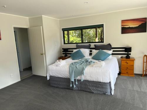 怀蒂昂格城堡树梢木屋的卧室配有带蓝色枕头的大型白色床