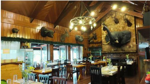 碧瑶Log Cabin Hotel - Safari Lodge Baguio的一间带桌椅和壁炉的用餐室