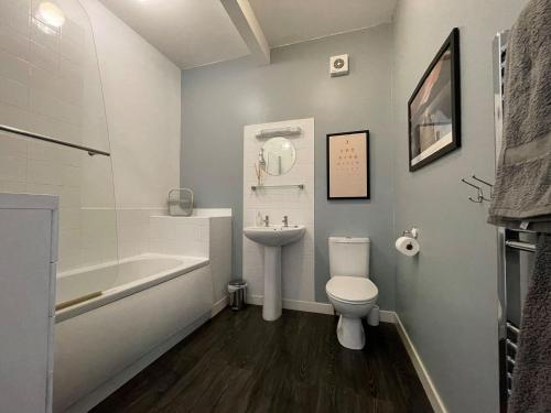 斯佩河畔格兰敦Seafield Lodge的浴室配有盥洗盆、卫生间和浴缸。
