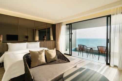 纳仲天Ana Anan Resort & Villas Pattaya的一间卧室设有一张床和一张沙发,享有海景