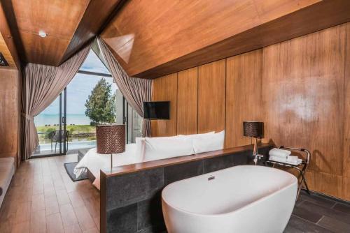 纳仲天Ana Anan Resort & Villas Pattaya的带浴缸和床的大型浴室