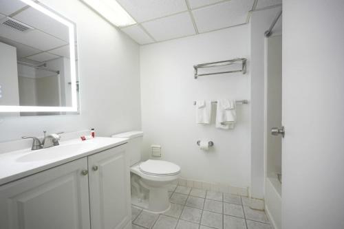 博林Greenwoods inn & Suites的白色的浴室设有卫生间和水槽。