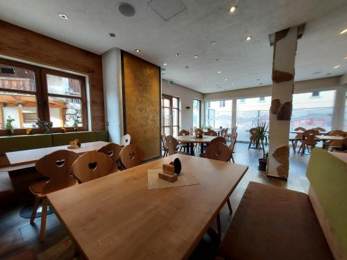 Feistritz an der Drau曾特拉尔宾馆的餐厅设有木桌、椅子和窗户。