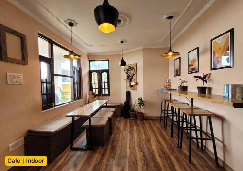 麦罗肯机Young Monk Hostel & Cafe Dharamkot的一间酒吧,里面设有凳子和柜台