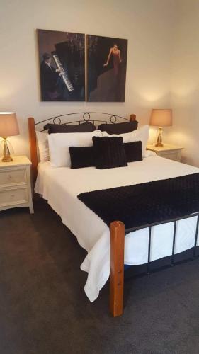 怀蒂昂格Waterways Escape的一间卧室配有一张带两盏灯的大型白色床。