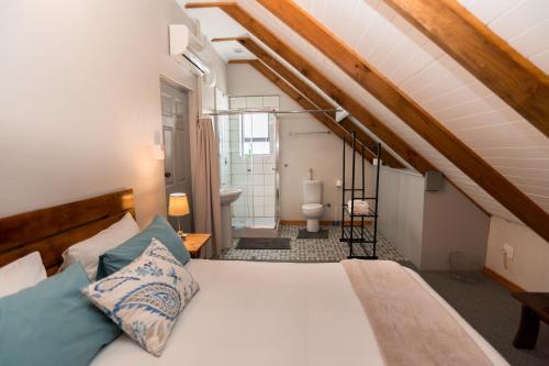 罗伯森Vlettershof Guest House的一间卧室设有一张床和一间浴室。