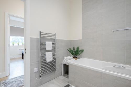 Modern Elegant Luxury 1 bed flat Free parking的白色的浴室设有浴缸和水槽。
