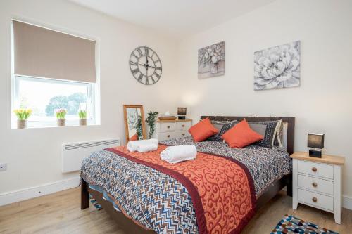 Modern Elegant Luxury 1 bed flat Free parking的一间卧室配有带橙色枕头的床和窗户。