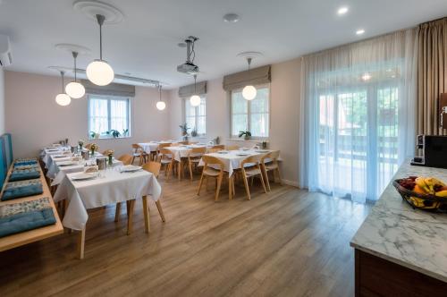 帕波Ditlin Apartmanok的餐厅设有白色的桌椅和窗户。