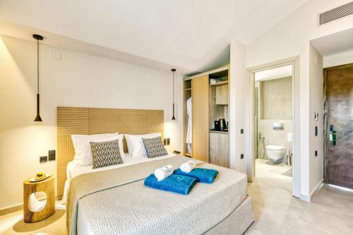 康托卡利Hidden Cove Corfu的一间卧室配有一张大床,上面有两条蓝色的毛巾