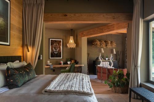 兰斯堡Lush Private Game Lodge的一间卧室配有一张大床和一张书桌