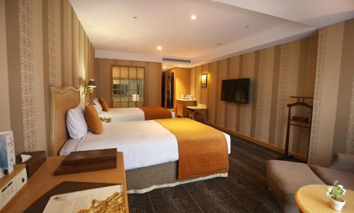 新庄新庄翰品酒店的酒店客房,设有两张床和一张沙发