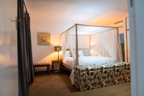 利隆圭Burley House by Ulendo的一间卧室配有一张带天蓬的床