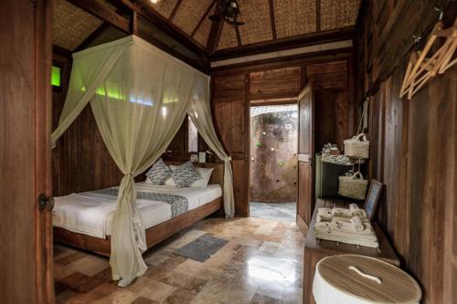 日惹Yabbiekayu Eco-Bungalows的一间卧室配有一张带天蓬的床