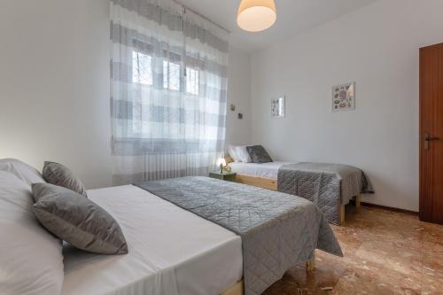 费拉拉Ferrara Charming apt 4 min walk from the bus stop!的酒店客房设有两张床和窗户。