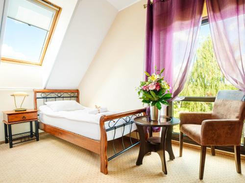 弗龙基瓦托斯劳酒店的卧室配有床、椅子和窗户。