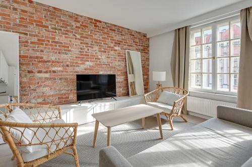 格但斯克Comfort Apartments Długi Targ的一间设有砖墙的客厅