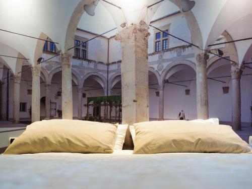 卡梅里诺Alla scoperta delle Marche的柱子间里一张带两个枕头的床