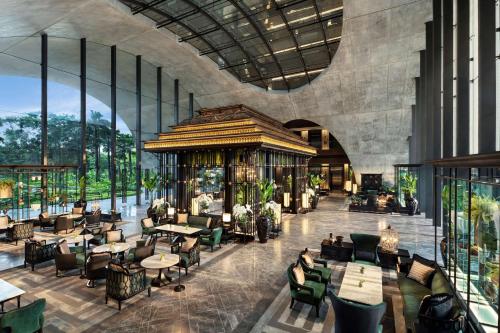 曼谷Sindhorn Kempinski Hotel Bangkok的餐厅的 ⁇ 染,配有桌椅