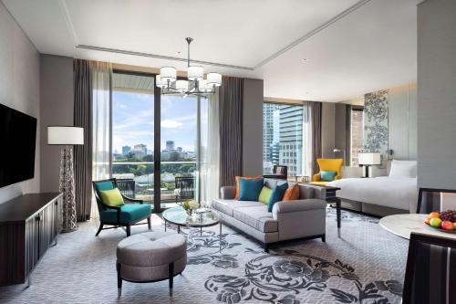 曼谷曼谷新通凯宾斯基酒店的酒店客房设有一张特大号床和一间客厅。