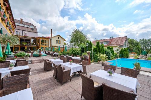 WindorfHotel Restaurant Zum Goldenen Anker mit Hallenbad & Wellnessbereich的一个带桌椅的庭院和一个游泳池