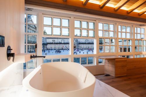 圣地亚哥－德孔波斯特拉Hotel Plaza Obradoiro by Bossh! Hotels的设有一个大浴缸的大窗户