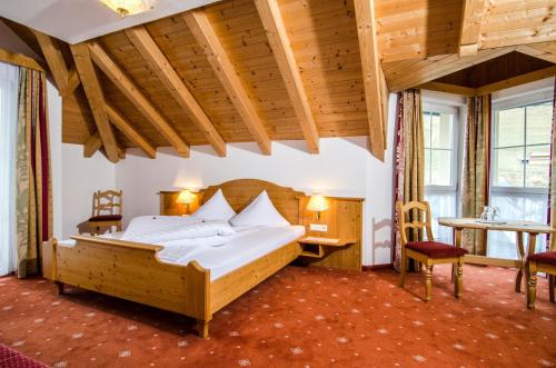 伊施格尔Hotel Garni Daniel的一间卧室配有一张大床和一张桌子及椅子