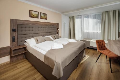 什平德莱鲁夫姆林Wellness Hotel Astra的酒店客房设有两张床和一张桌子。