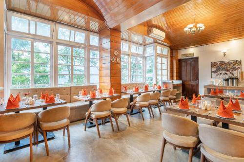 甘托克Summit Alpine Abode Hotel Centrally Air Conditioned的餐厅配有桌椅和橙色锥形锥形