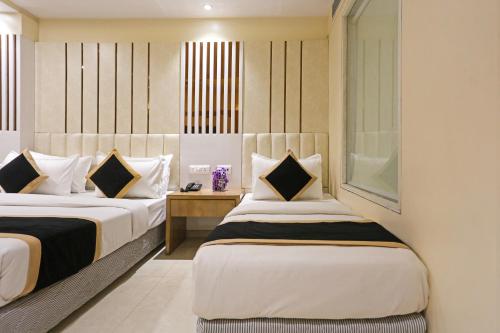 新德里Hotel Worth - Near Railway Station的酒店客房设有两张床和窗户。