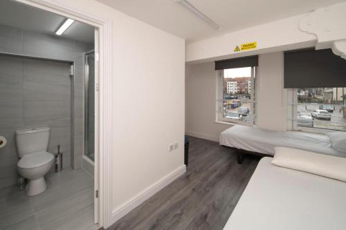 布里斯托Harbourside Hostel Bristol的一间卧室设有一张床、一个卫生间和一个窗口
