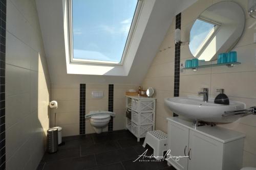 SüdbrookmerlandPension Lütje Huske Zimmer 3的浴室配有水槽和带天窗的卫生间。