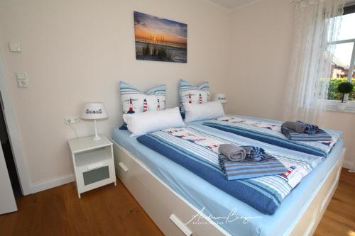SüdbrookmerlandPension Lütje Huske Zimmer 2的一间卧室配有一张带蓝色和白色枕头的床