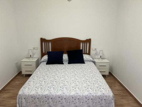 PliegoAgradable casa familiar en Pliego.的一间卧室配有一张带蓝色枕头的床和2个床头柜