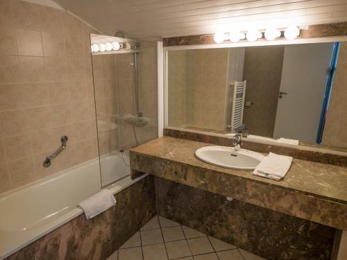 昂代梅索柯布鲁高尔夫酒店的一间带水槽、淋浴和镜子的浴室