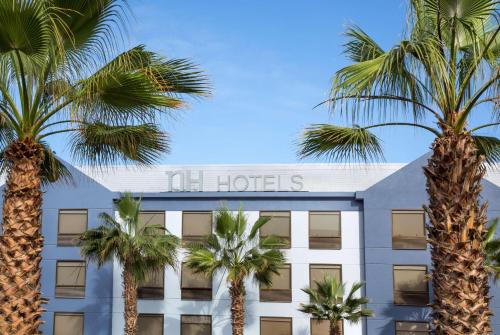 伊基克NH Iquique Costa的前面有棕榈树的酒店