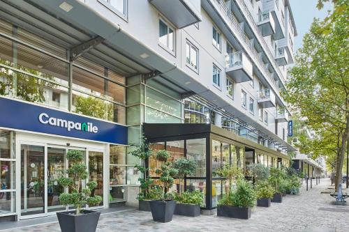 巴黎Hotel Campanile Paris-Bercy Village的一座种植盆栽植物的建筑的前方