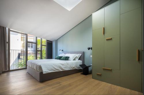 米兰Heart Milan Apartments Porta Romana的一间卧室设有一张床和一个大窗户