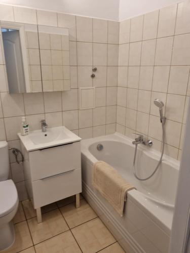 格丁尼亚Apartament na Żeromskiego的带浴缸、盥洗盆和卫生间的浴室