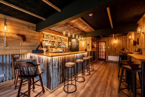 UnapoolNewton Lodge的酒吧设有木墙和酒吧凳